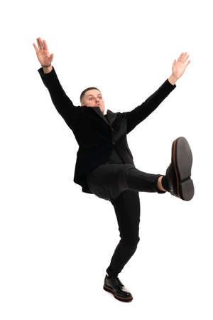 Full length shot of a young handsome man in a black suit walking isolated on white backgroundの写真素材