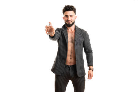 Man hold perfume bottle. Bearded man with deodorant isolated on white backgroundの写真素材