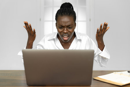 Sad young woman sit at laptop broken after reading bad news online, upset girlfriend hurt receive breakup or split message from lover, desperate female get negative email losing hope or failure noticeの写真素材