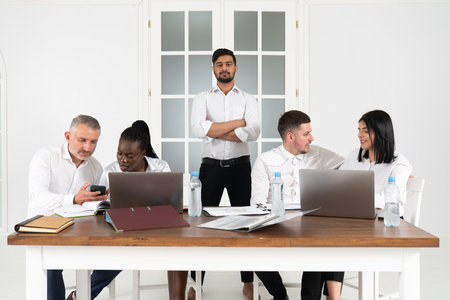 Indian businessman boss with group of business people In creative office, successful mix race man...