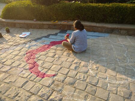 Female Painter painting on groundの写真素材