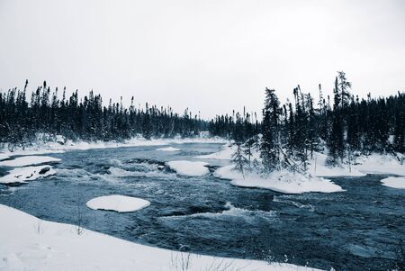 A winter landscape showing a foggy river in blue tonesの写真素材