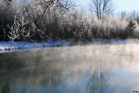 A winter landscape showing a foggy river on a cold dayの写真素材