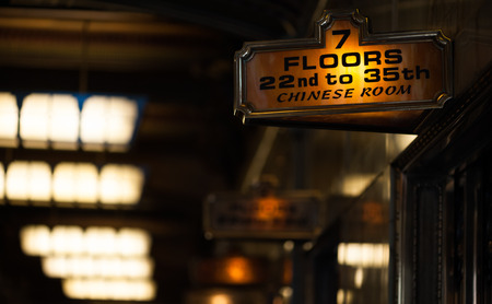An orange illuminated sign shows the correct floor for the famous Chinese room in the Smith Tower, Pioneer Square, Seattle.のeditorial素材