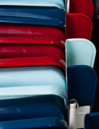 Closeup shot of a stack of battered folding metal chairs painted red, white and blue.の写真素材