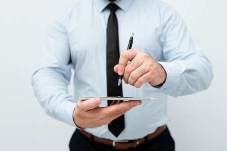 close up hand young man are sitting using pen writing Record Lecture note pad into the book on the table wood.の写真素材