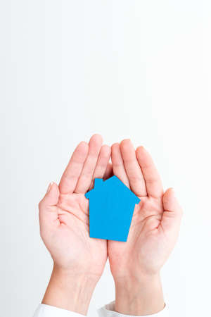 Hand Holdign Paper House With Care And Affection, Higlighting Real Estate And Your Own House Ownership. Looking After Supervision Your Home And Renting The House.の写真素材
