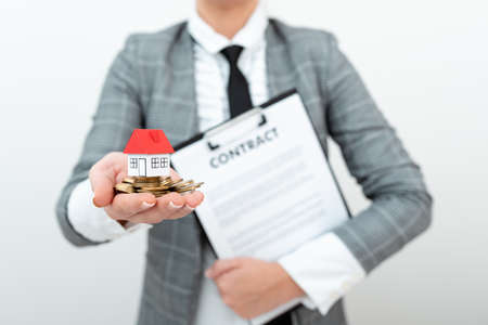 Lady Carrying Home And Contract For Signing In Outfit, Business Woman Holding House With Agreement For New Mortegage, Residence Expressed By Recent Sale, Apartments Auctionsの写真素材