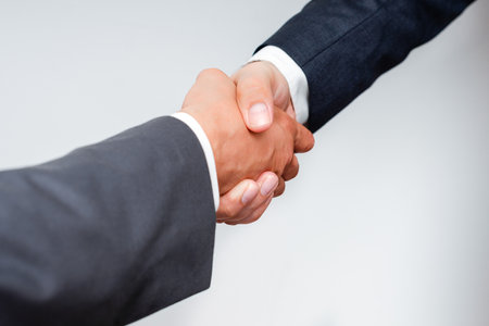 Corporate Businessmen Handshake Indoors.Two People Professionally Well Dressed Gesturing Togetherness.Working Colleague Partners Sign Deal In Agreement To Contractの写真素材