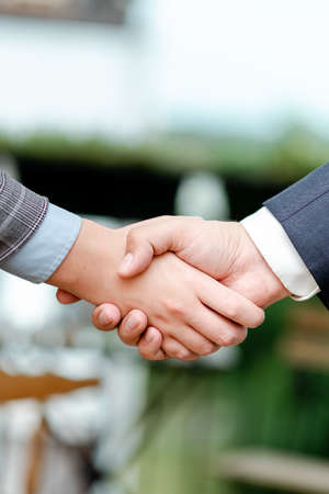 Corporate Businessmen Handshake Indoors.Two People Professionally Well Dressed Gesturing Togetherness.Working Colleague Partners Sign Deal In Agreement To Contractの写真素材