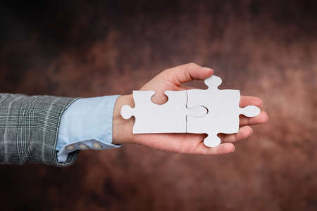 Hands Holding Two Pieces Of Jigsaw Puzzle.Cooperation For Finding And Resolving Missing Ideas At...
