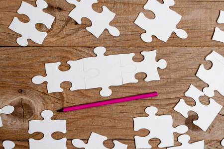 Close-Up White Jigsaw Pattern Puzzle Pieces To Be Connected With Missing Last Piece Positioned On A...