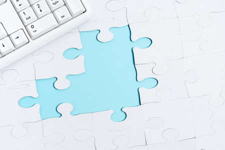Close-Up White Jigsaw Pattern Puzzle Pieces To Be Connected With Missing Last Piece Positioned On A Flat Lay Background With Different Texture And Paper Supplies Accesoriesの写真素材