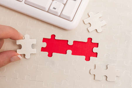 Close-Up White Jigsaw Pattern Puzzle Pieces To Be Connected With Missing Last Piece Positioned On A Flat Lay Background With Different Texture And Paper Supplies Accesoriesの写真素材