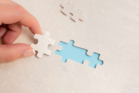 Close-Up White Jigsaw Pattern Puzzle Pieces To Be Connected With Missing Last Piece Positioned On A...