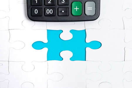 Close-Up White Jigsaw Pattern Puzzle Pieces To Be Connected With Missing Last Piece Positioned On A Flat Lay Background With Different Texture And Paper Supplies Accesoriesの写真素材