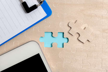 Close-Up White Jigsaw Pattern Puzzle Pieces To Be Connected With Missing Last Piece Positioned On A...