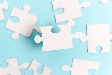 Close-Up White Jigsaw Pattern Puzzle Pieces To Be Connected With Missing Last Piece Positioned On A Flat Lay Background With Different Texture And Paper Supplies Accesoriesの写真素材