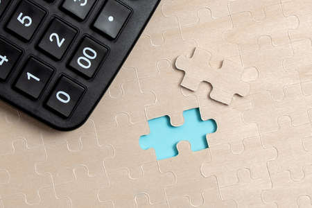 Close-Up White Jigsaw Pattern Puzzle Pieces To Be Connected With Missing Last Piece Positioned On A Flat Lay Background With Different Texture And Paper Supplies Accesoriesの写真素材