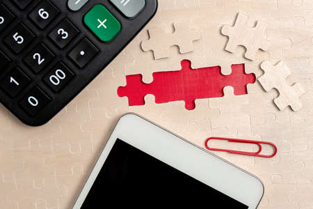 Close-Up White Jigsaw Pattern Puzzle Pieces To Be Connected With Missing Last Piece Positioned On A Flat Lay Background With Different Texture And Paper Supplies Accesoriesの写真素材