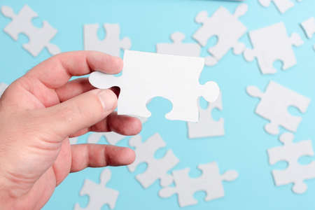 Close-Up White Jigsaw Pattern Puzzle Pieces To Be Connected With Missing Last Piece Positioned On A Flat Lay Background With Different Texture And Paper Supplies Accesoriesの写真素材