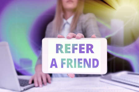 Conceptual caption Refer A Friend. Word for direct someone to another or send him something like gift Business Woman Sitting In Office Holding Mobile Displaying Futuristic Ideas.の写真素材