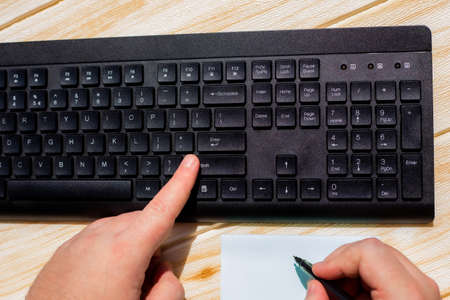 Hands Pressing Computer Keyboard Keys While Writing With Pencil In Notepad. Palms Typing Notebook...