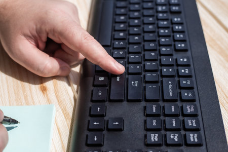 Hands Pressing Computer Keyboard Keys While Writing With Pencil In Notepad. Palms Typing Notebook...