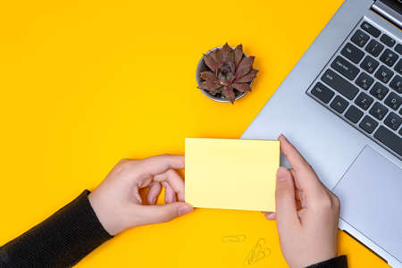 Woman Hand Holding Blank Notes Writing New Messege Updates Ideas Next To Laptop. Lady Palm Showing...