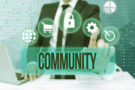 Text caption presenting Community. Business approach group of showing living in one place having a characteristic in common Bussiness Man Sitting Desk Laptop And Phone Pointing Futuristic Technology.の写真素材