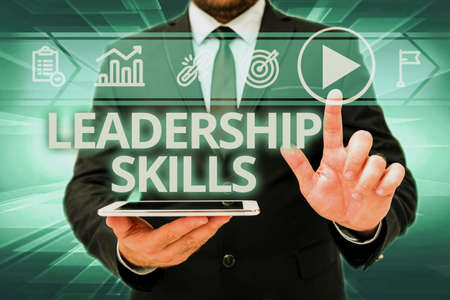 Hand writing sign Leadership Skills. Internet Concept Skills and qualities that leaders possess Taking a lead Man In Office Uniform Standing Pressing Virtual Button Holding Tablet.の写真素材