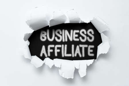 Inspiration showing sign Business Affiliate. Business idea one company is a minority shareholder of another Tear on sheet reveals background behind the front sideの写真素材