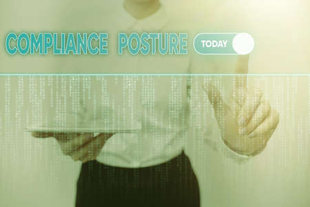 Conceptual caption Compliance Posture. Business overview manage the defense of the enterprise and assure resources Lady Holding Tablet Pressing On Virtual Button Showing Futuristic Tech.の写真素材