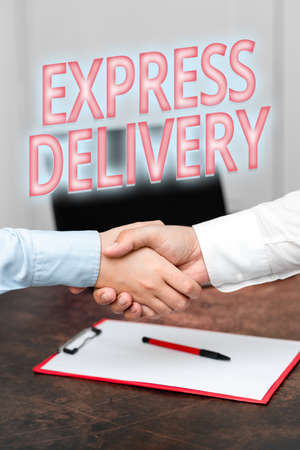 Conceptual caption Express Delivery. Business approach expediting the distributiuon of goods and services Two Professional Well-Dressed Corporate Businessmen Handshake Indoorsの写真素材