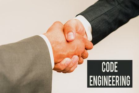 Writing displaying text Code Engineering. Business overview application of engineering to the development of software Two Professional Well-Dressed Corporate Businessmen Handshake Indoorsの写真素材