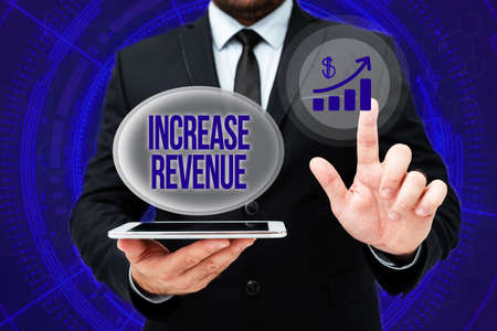 Inspiration showing sign Increase Revenue. Concept meaning increase in a company s is sales from one period to the next Man In Office Uniform Standing Pressing Virtual Button Holding Tablet.の写真素材
