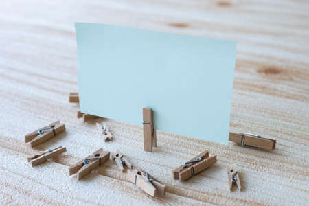 Blank Square Note Surrounded By Laundry Clips Showing New Meaning. Empty Piece Of Sticky Paper Clipped Upright Placed On Top Of Wooden Table Displaying Fresh Idea.の写真素材