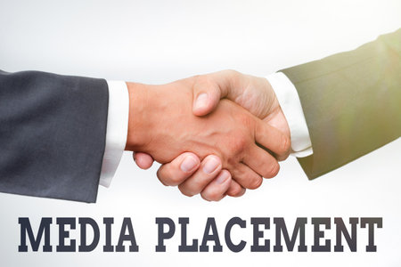 Conceptual caption Media Placement. Business concept the method of placing your ad message using the media Two Professional Well-Dressed Corporate Businessmen Handshake Indoorsの写真素材