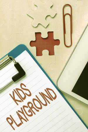 Text sign showing Kids Playground. Word for piece of land designed for children to play in outside Building An Unfinished White Jigsaw Pattern Puzzle With Missing Last Pieceの写真素材