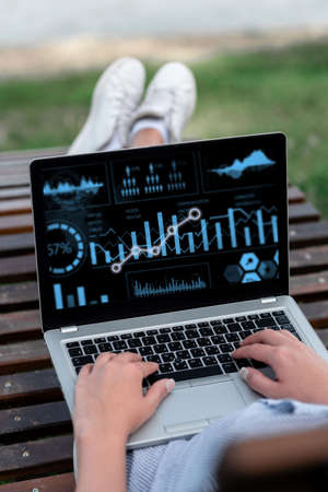 Laptop Resting On Lap Of Woman With Cross Leg Outdoors Accomplishing Her Remote Job. Minicomputer Placed Surface Upper Part Legs Outside Doing Computer Works.の写真素材