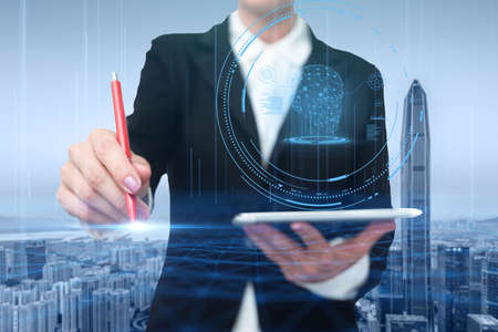 Woman In A Suit Virtually Writing On Screen Holding Tablet Showing Futuristic Technology. Businesswoman Wearing Uniform Handwriting Using Pad Presenting Modern Automation.の写真素材