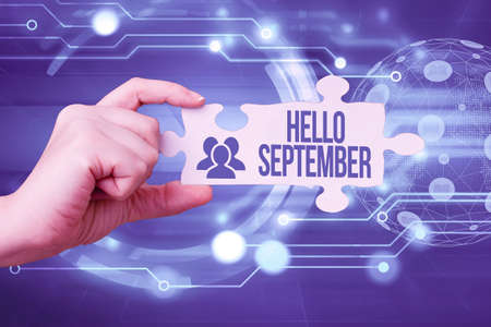 Conceptual caption Hello September. Business concept Eagerly wanting a warm welcome to the month of September Hand Holding Jigsaw Puzzle Piece Unlocking New Futuristic Technologies.の写真素材