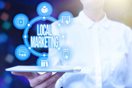Text sign showing Local Marketing. Business approach A local business where a product buy and sell in area base Lady Uniform Standing Tablet Hand Presenting Virtual Modern Technologyの写真素材