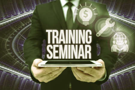Text sign showing Training Seminar. Internet Concept Academic instruction Formal presentation of a research Man In Office Uniform Holding Tablet Displaying New Modern Technology.の写真素材