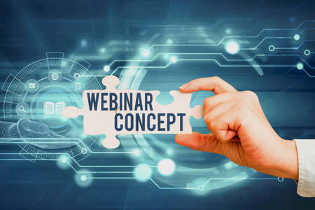 Text showing inspiration Webinar Concept. Business approach workshop or seminar that is transmitted over the Web Hand Holding Jigsaw Puzzle Piece Unlocking New Futuristic Technologies.の写真素材