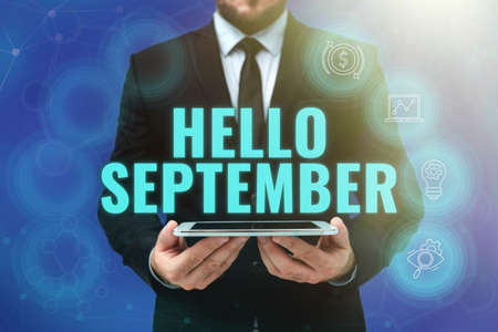 Sign displaying Hello September. Word for Eagerly wanting a warm welcome to the month of September Man In Office Uniform Holding Tablet Displaying New Modern Technology.の写真素材