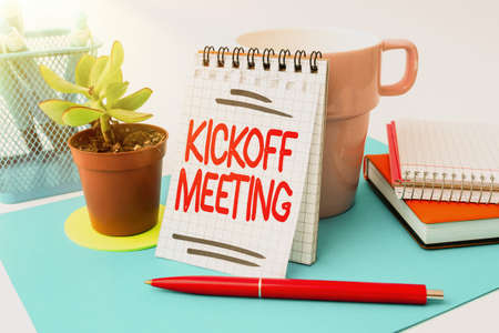 Sign displaying Kickoff Meeting. Business approach Special discussion on the legalities involved in the project Tidy Workspace Setup Writing Desk Tools And Equipment Taking Notesの写真素材