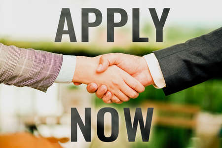 Handwriting text Apply Now. Concept meaning request something officially in writing or by sending in form Two Professional Well-Dressed Corporate Businessmen Handshake Indoorsの写真素材
