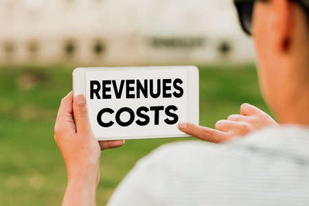 Hand writing sign Revenues Costs. Internet Concept Total amount of money in Manufacturing and Delivery a product Voice And Video Calling Capabilities Connecting People Togetherの写真素材