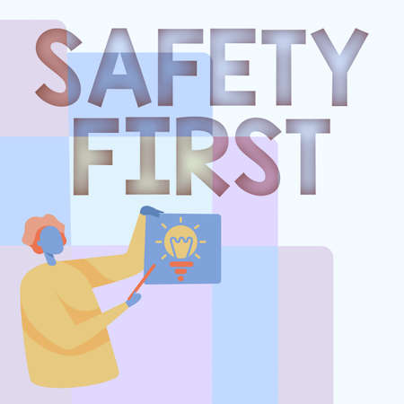 Inspiration showing sign Safety First. Word for used to say that the most important thing is to be safe Man Standing Holding Paper With Glowing Light Bulb While Pointing Stick.の写真素材